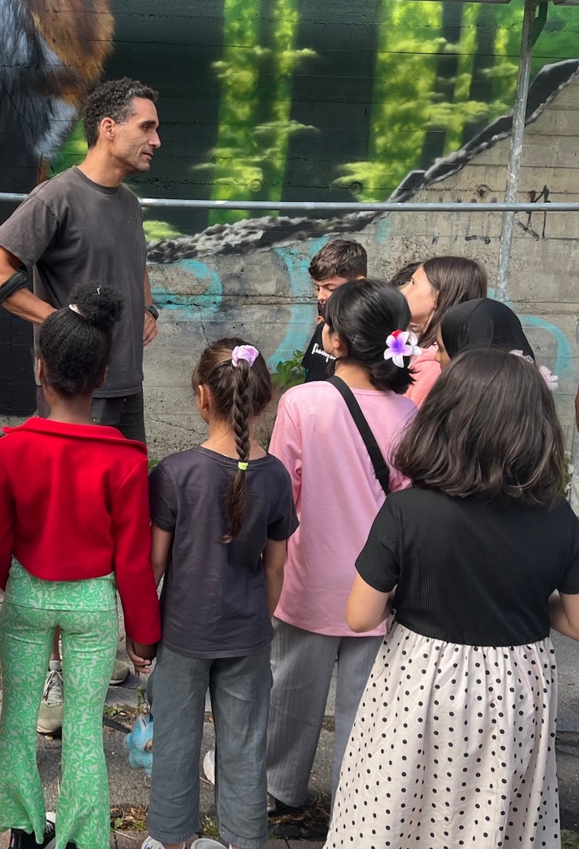De kinderen van de basisschool bezochten de kunstenaar Alex, die de gevel van de bunker ontwierp, en mochten ook zelf proberen te spuiten.