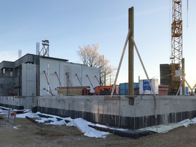 De geprefabriceerde muren op de begane grond worden opgetrokken.