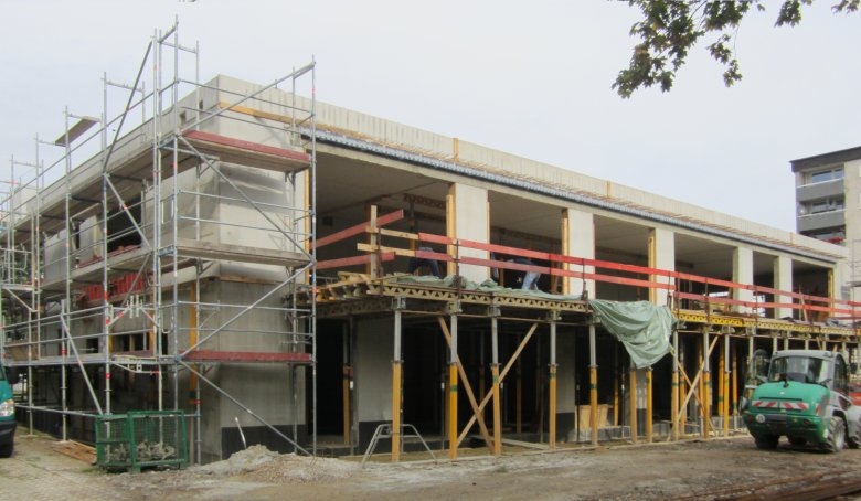 Het balkon is gedeeltelijk betonnen. Je kunt het balkon met de steiger zien.