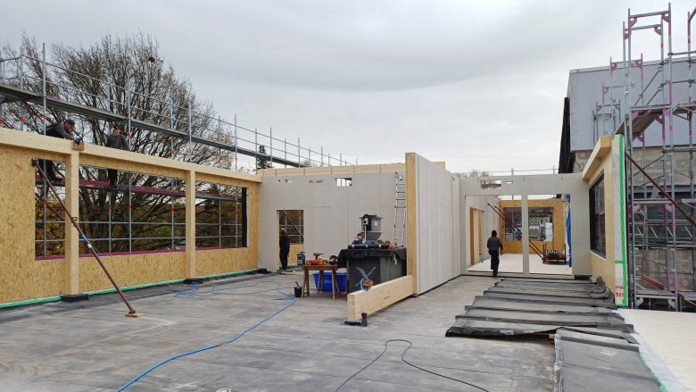 Houten paneelmuren worden opgetrokken.