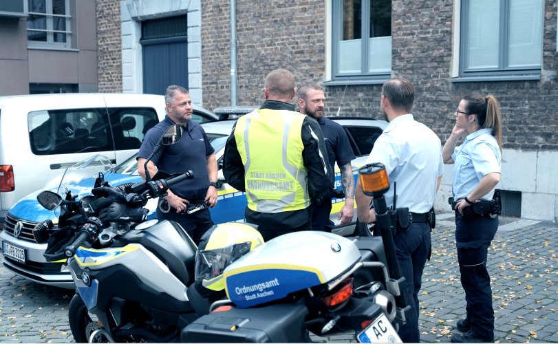 OSD Een groep beveiligingsmedewerkers staat te kletsen.