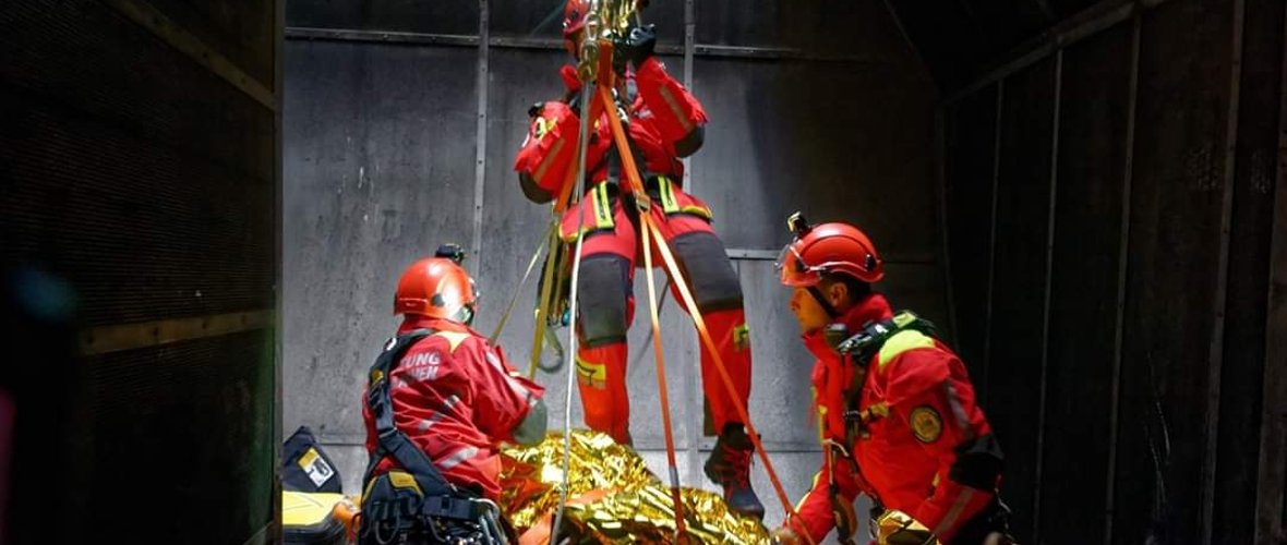 Redding van een patiënt uit een schacht met behulp van een mandbrancard met initiële medische behandeling door hoogteredders.
