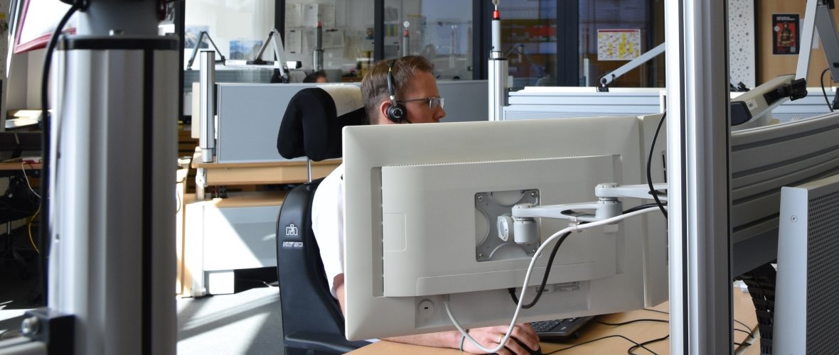 Een medewerker zit aan zijn bureau en neemt meteen de volgende noodoproep aan.