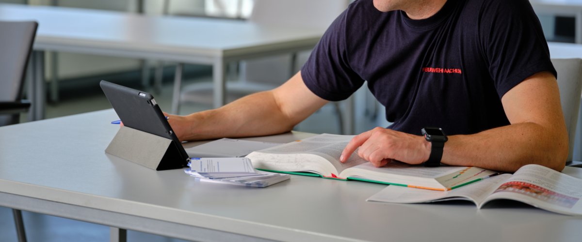 Opleiding en bijscholing Een leerling leert met een iPad en boeken, maar ook met zijn aantekeningen op indexkaarten.