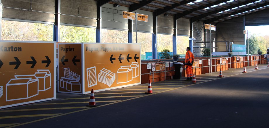 Oranje containers met mededelingen voor papier, grofvuil, karton