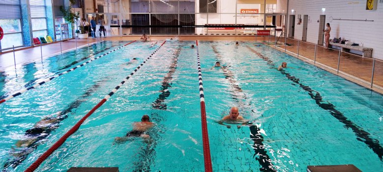 Een paar zwemmers doen hun baantjes in het zwembad van de Ulla Klinger Hall.
