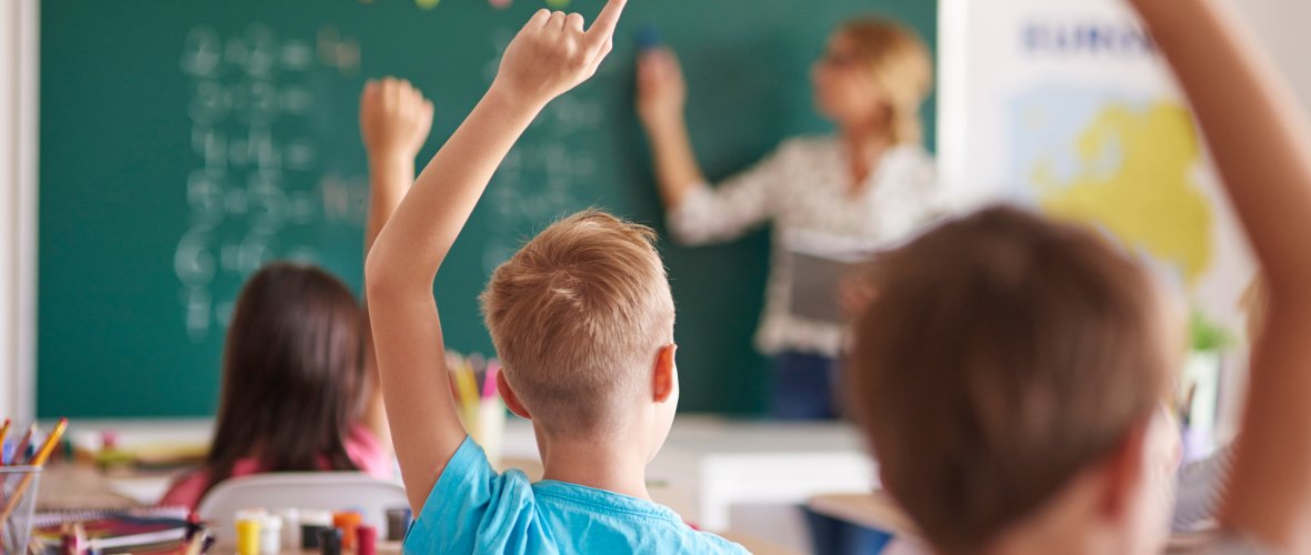 Kinderen op een school die vingers hebben om opgehaald te worden.