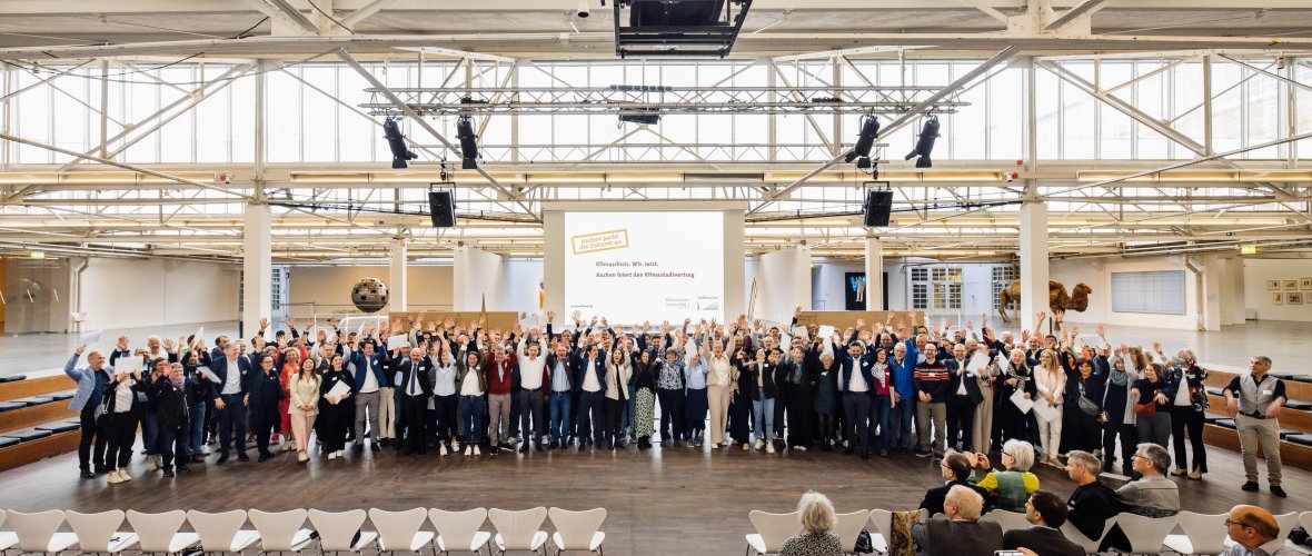 Klimaatstad contract Een grote zaal met stoelen en veel mensen die op een rij staan.