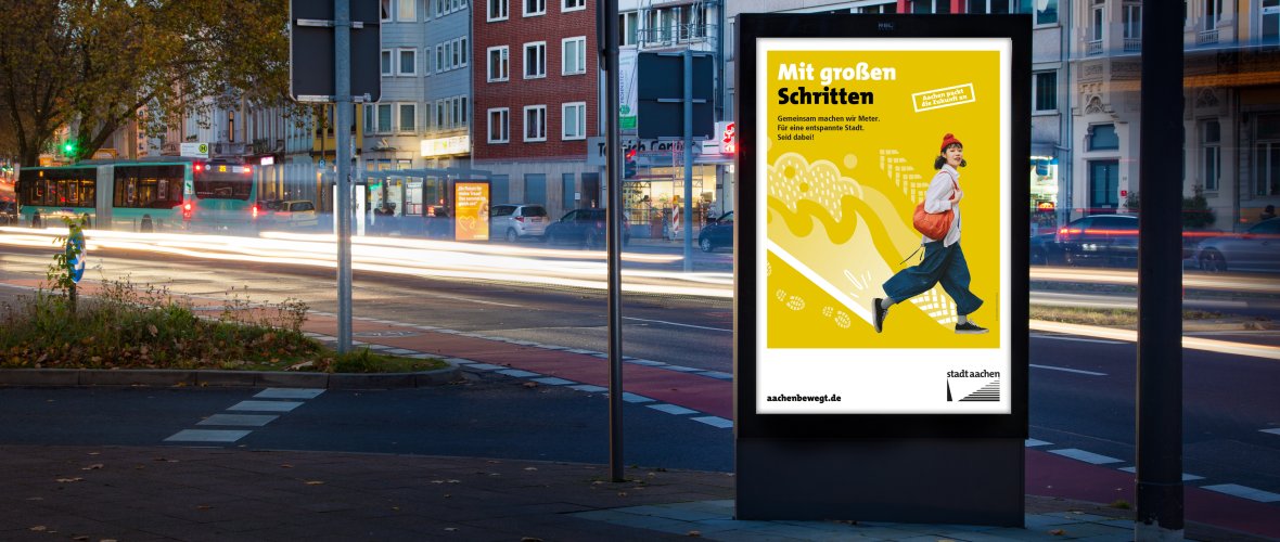 Transport Bushalte met bus in de schemering met posterinstallatie op de voorgrond Kaiserplatz Aachen