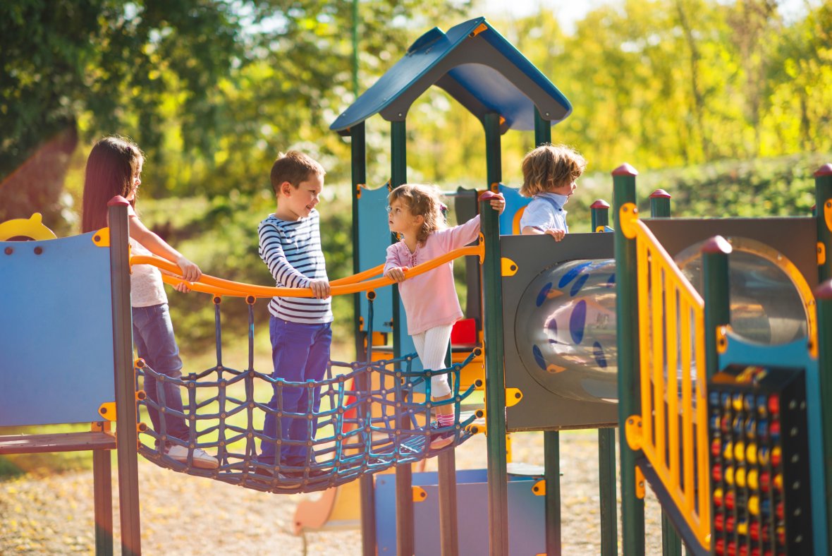 Een kleine groep kinderen vermaakt zich op het klimrek en kletst.