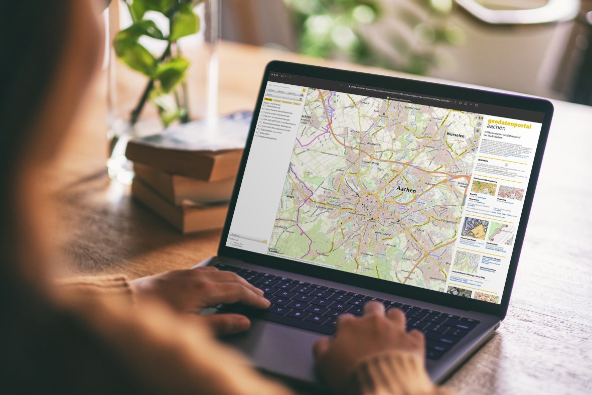 Een vrouw die een laptop gebruikt en de geodata portaalpagina opent.