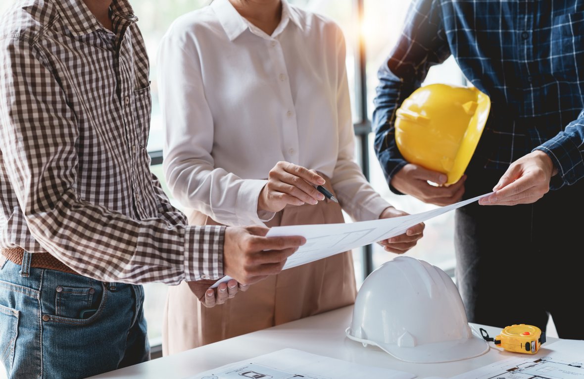 Architecten of ingenieurs komen bijeen om een bouwplan te bespreken.