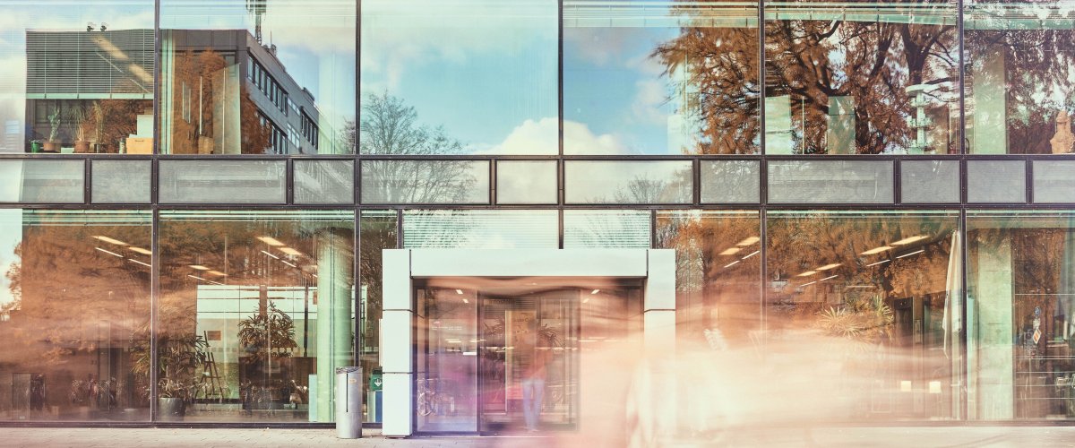 De ingang en de glazen gevel van de Super C van de RWTH Aachen University in het zonlicht.