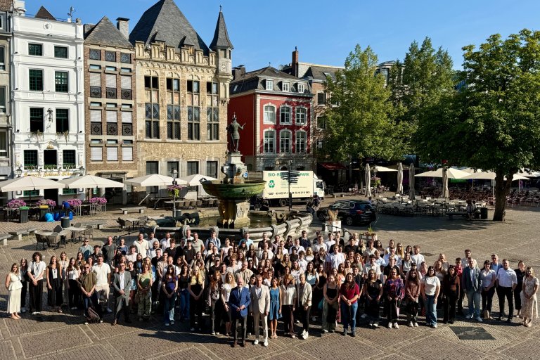 Van harte welkom in de stad Aken Een groepje mensen staat bij de Karelsbron en kijkt uit naar de start van de opleiding.