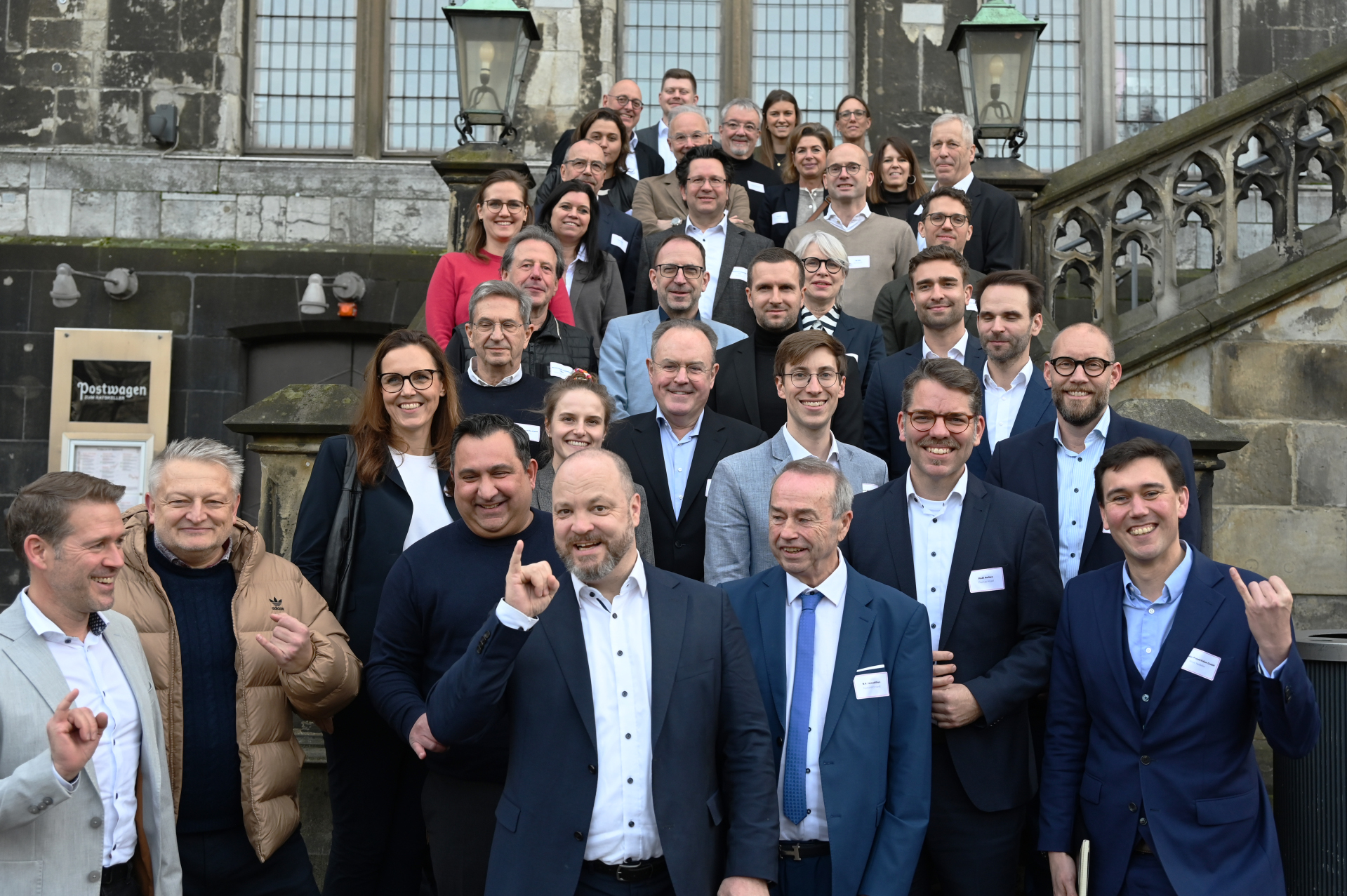 Een groep mensen staat op de trappen van het stadhuis.