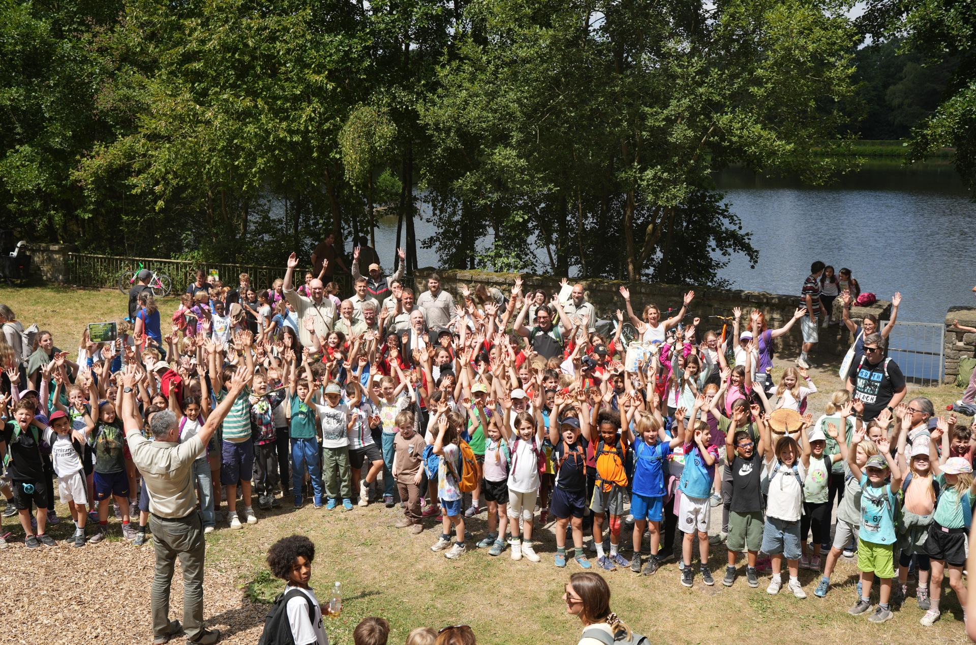 240 kinderen staan op een speelplaats en juichen.