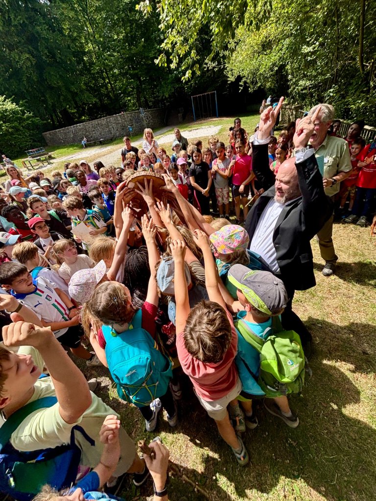 Kinderen vieren samen met de burgemeester hun overwinning bij de Waldjugendspiele.