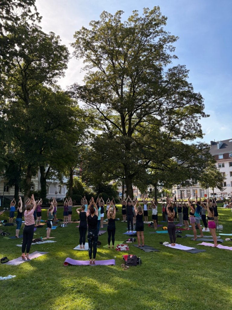 Zonnegroet in het park Een groep mensen doet aan yoga in het park.