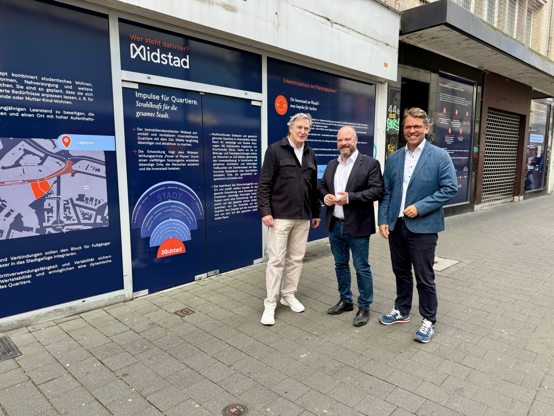 Drie mannen staan voor een met stickers beplakte etalageruit.