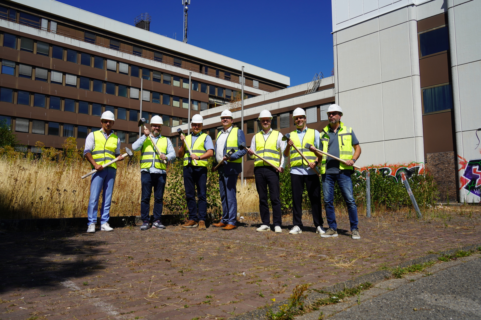 Een groep met helmen voor een gebouw