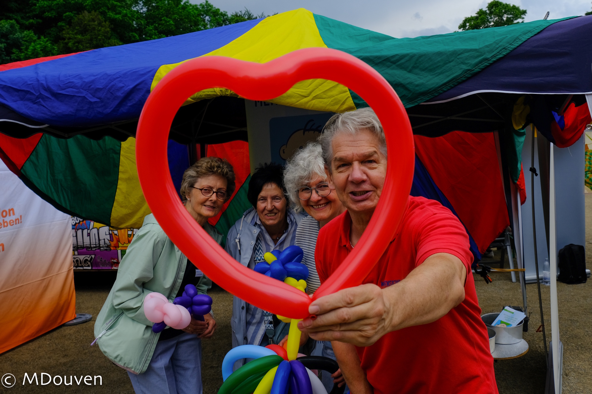Mensen kijken door een hart gemaakt van ballonnen