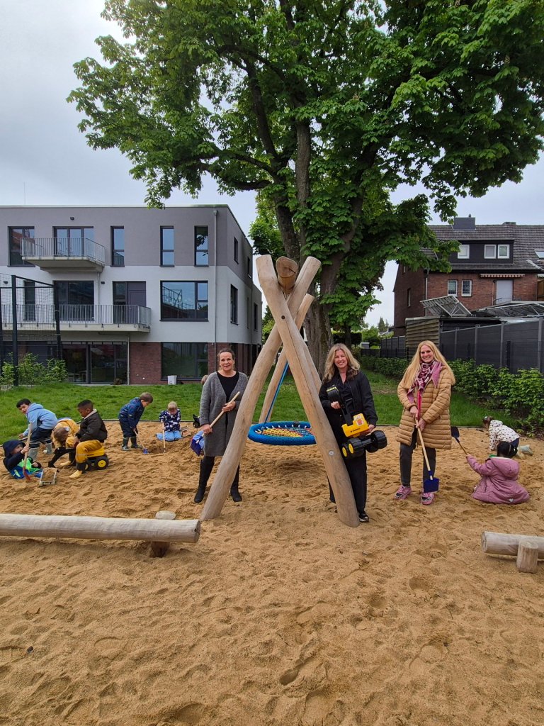 Kinderen en volwassenen in een zandbak