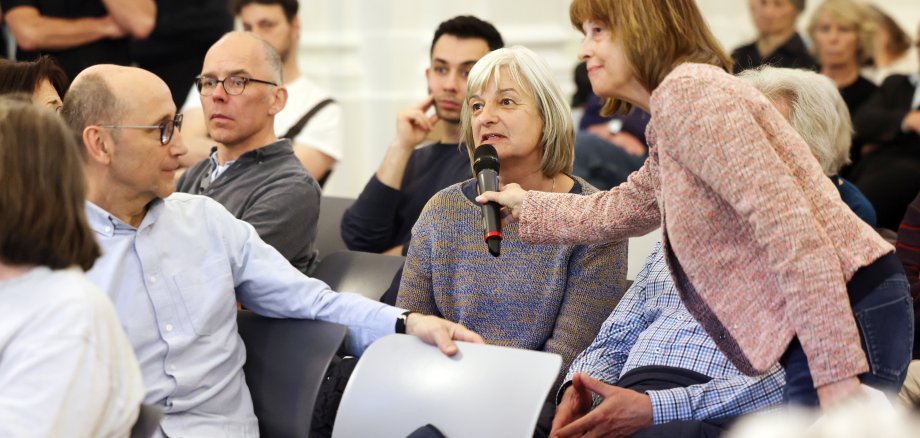 Mensen in discussie. Vrouw houdt een microfoon vast voor een andere vrouw