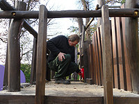 Ein Mitarbeiter der Spielplatzkontrolle repariert ein Klettergerüst