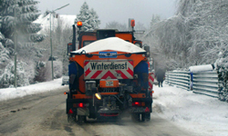Heckansicht eines Winterräumfahrzeuges auf verschneiter Straße