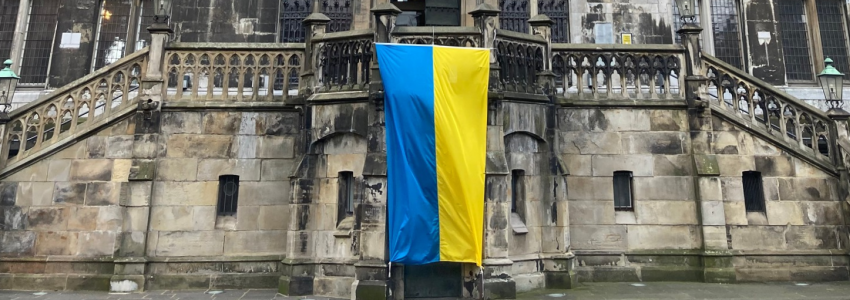 Das Aachener Rathaus. Eine Ukraineflagge, blau und gelb, hängt am Balkon.