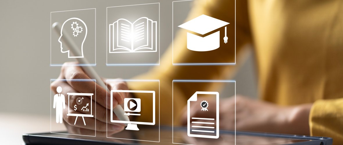 Education Distance E-learning Online Learning Personal development concept. Ein Hand hält einen Stapel Bücher vor einen Bildschirm