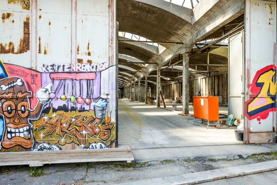 Blick in die Halle des Depots mit Stützen im Umbau, rechts und links Außenwände mit Graffiti