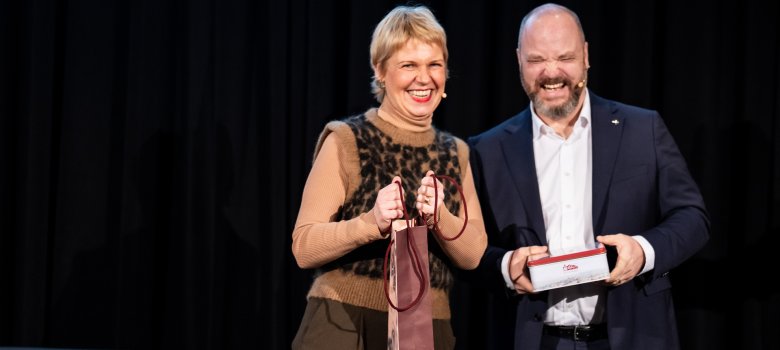 Neujahrsempfang 2026 Cordula Stratmann und Oberbürgermeister Dr. Michael Ziemons stehen nebeneinander auf der Bühne und lachen.