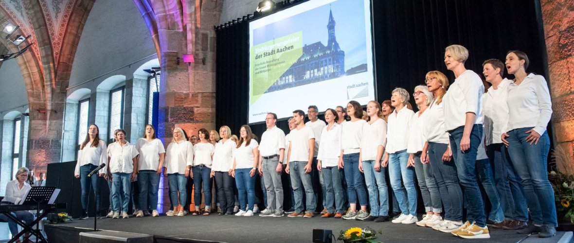 Chor singt auf Bühne im Rathaus