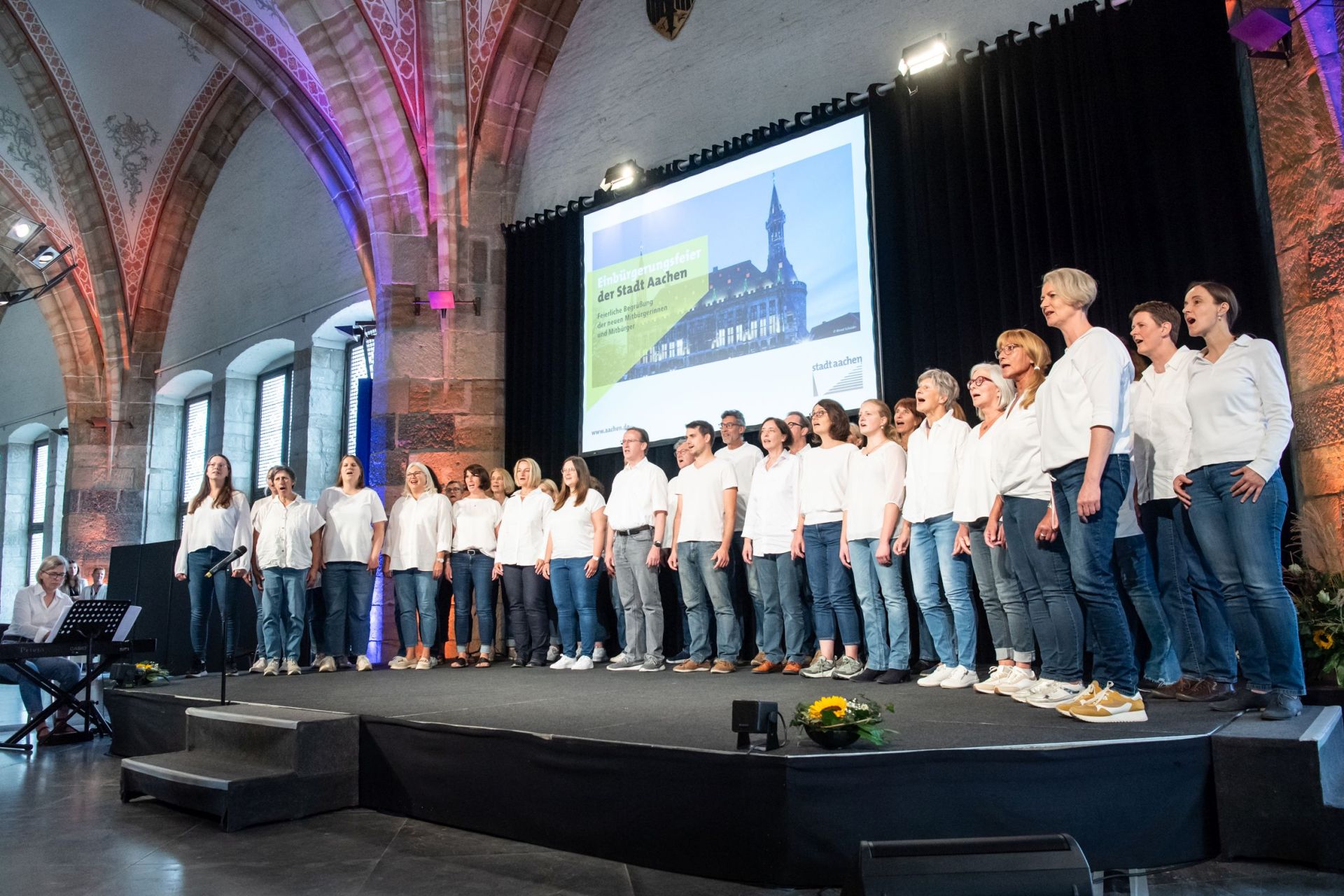 Chor singt auf Bühne im Rathaus