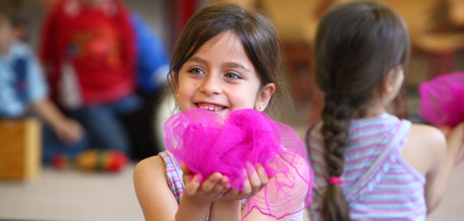 Kind hält violettes Tuch in den Händen