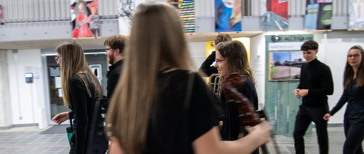 eine Gruppe von jungen Instrumentalist*innen freut sich auf ihren Auftritt