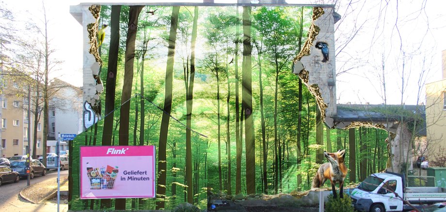 Eine Wandgestaltung mit Bäumen und einen lächelnden Person im Hintergrund