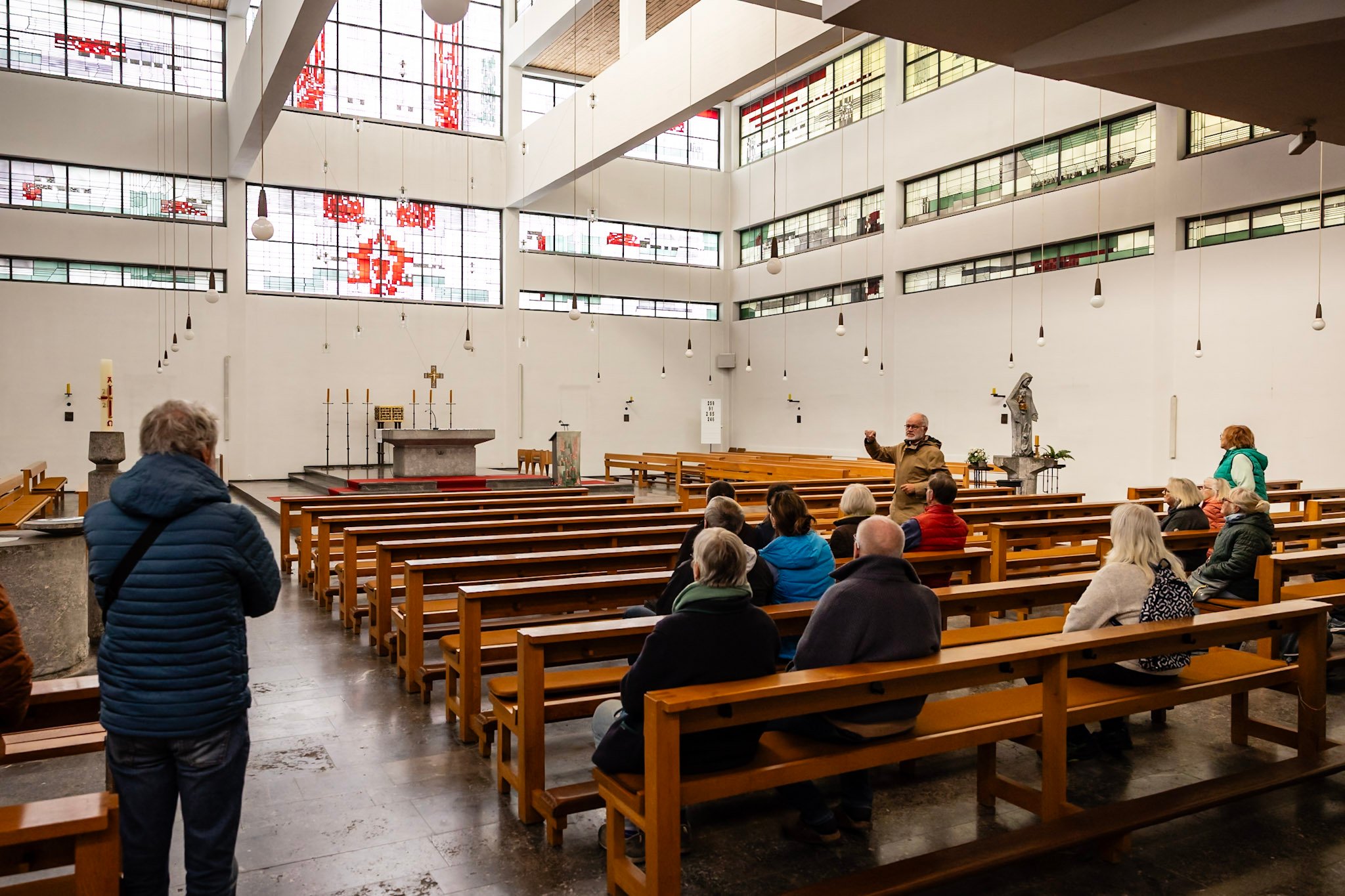 Ein paar Gäste sitzen auf den hölzernen Bänken der Kirche St. Bonifatius