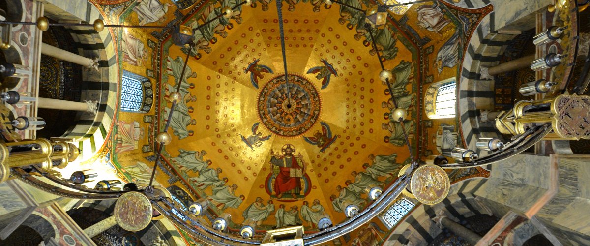Innenansicht des Aachener Doms. Blick in die Kuppel des Oktogons mit Barbarossaleuchter.