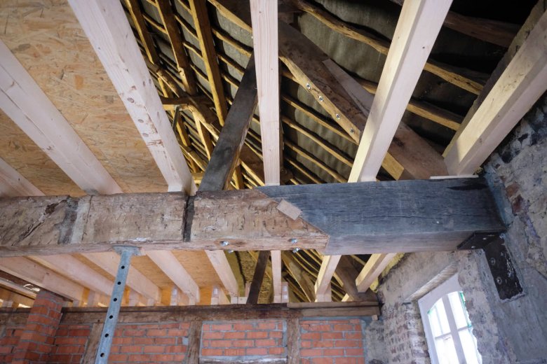 Teile eines alten Holzbalkens wurden ersetzt und aufwendig angearbeitet.