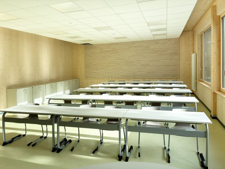 Klassenraum mit Akustikrückwand und sichtbarem Bereich der Holzdecke. 
