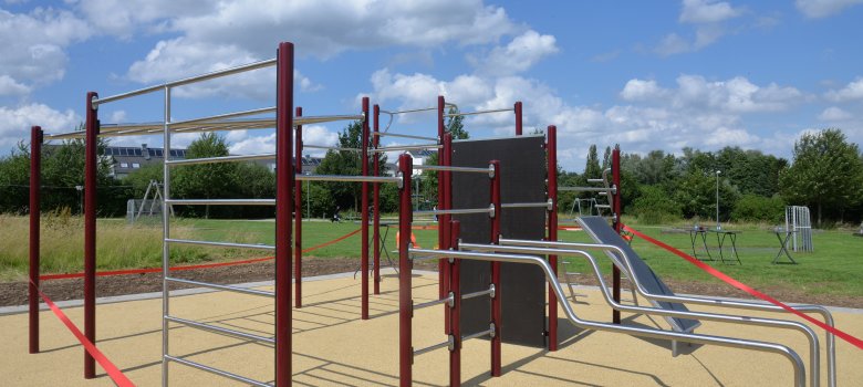 Eine Calisthenics-Anlage bei Sonnenschein. Es gibt viele Stangen, um mit dem Körpergewicht seine Muskulatur und die Körperkoordination zu trainieren.