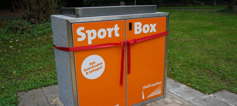 Die orangene Sportbox mit einer Schleife von außen.
