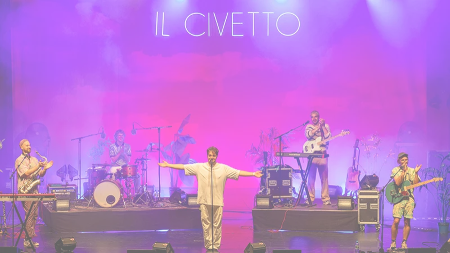 Die Band Il Civetto steht auf einer Bühne, der Hintergrund ist lila ausgeleuchtet