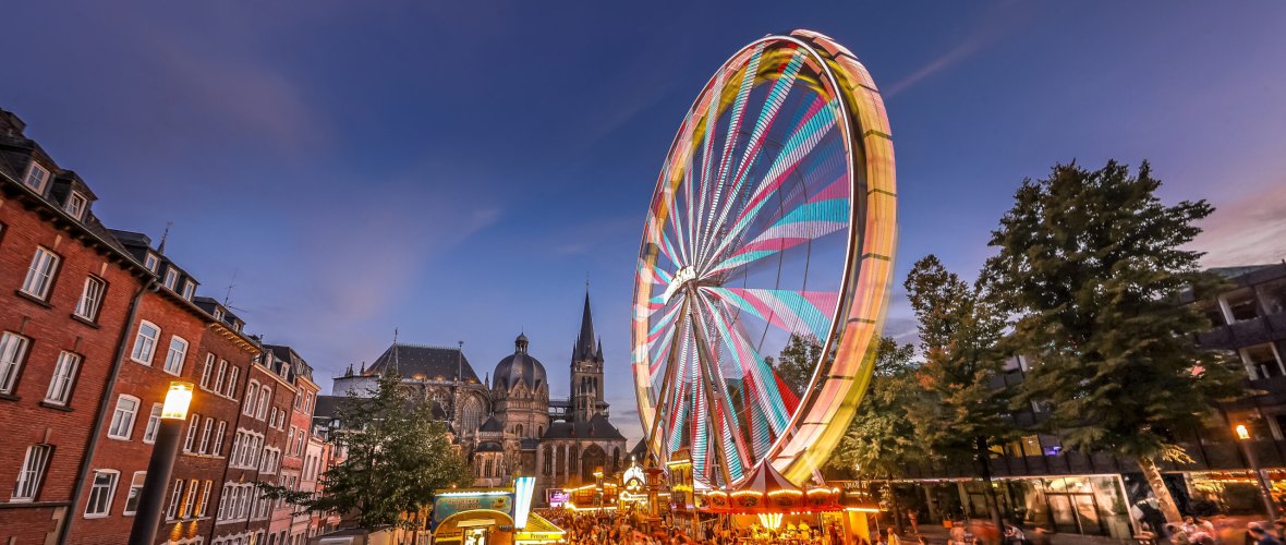 Das beleuchtete Riesenrad in der Abenddämmerung.