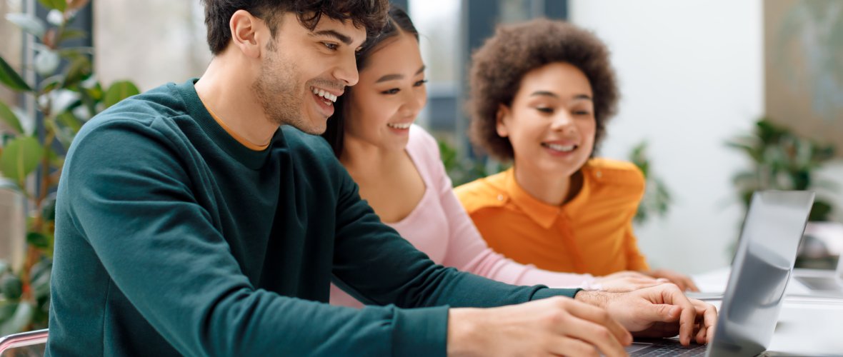 Eine vielfältige Gruppe von Student*innen, die an einem Projekt zusammenarbeiten.