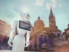 Fortschritt Ein Roboter mit einem Schild "Wir machen Fortschritt möglich." steht vor dem Dom.