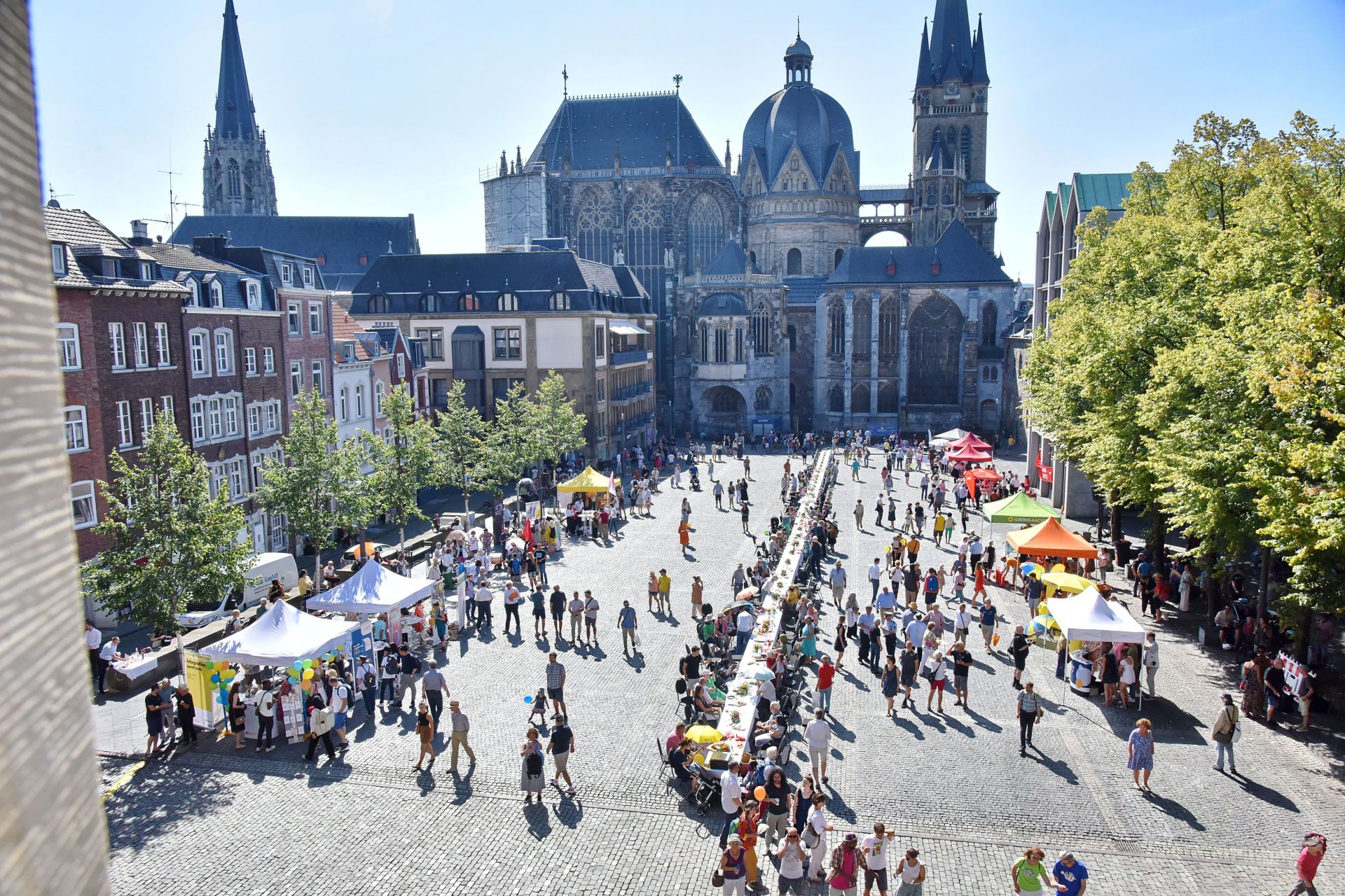Die lange Tafel der Vielfalt auf dem Katschof, darum viele Menschen. Von einem Fenster im Rathaus aufgenommen.