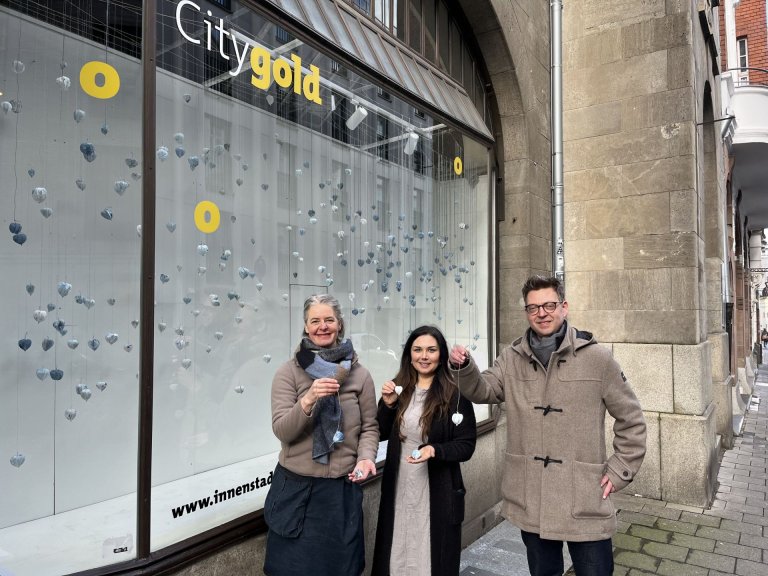 (v.l.n.r.) Künstlerin Sandra Ganser sowie Dina Bharucha und Kai Hennes vom Citymanagement vor dem neuen Kunst-Schaufenster in der Elisabethstraße